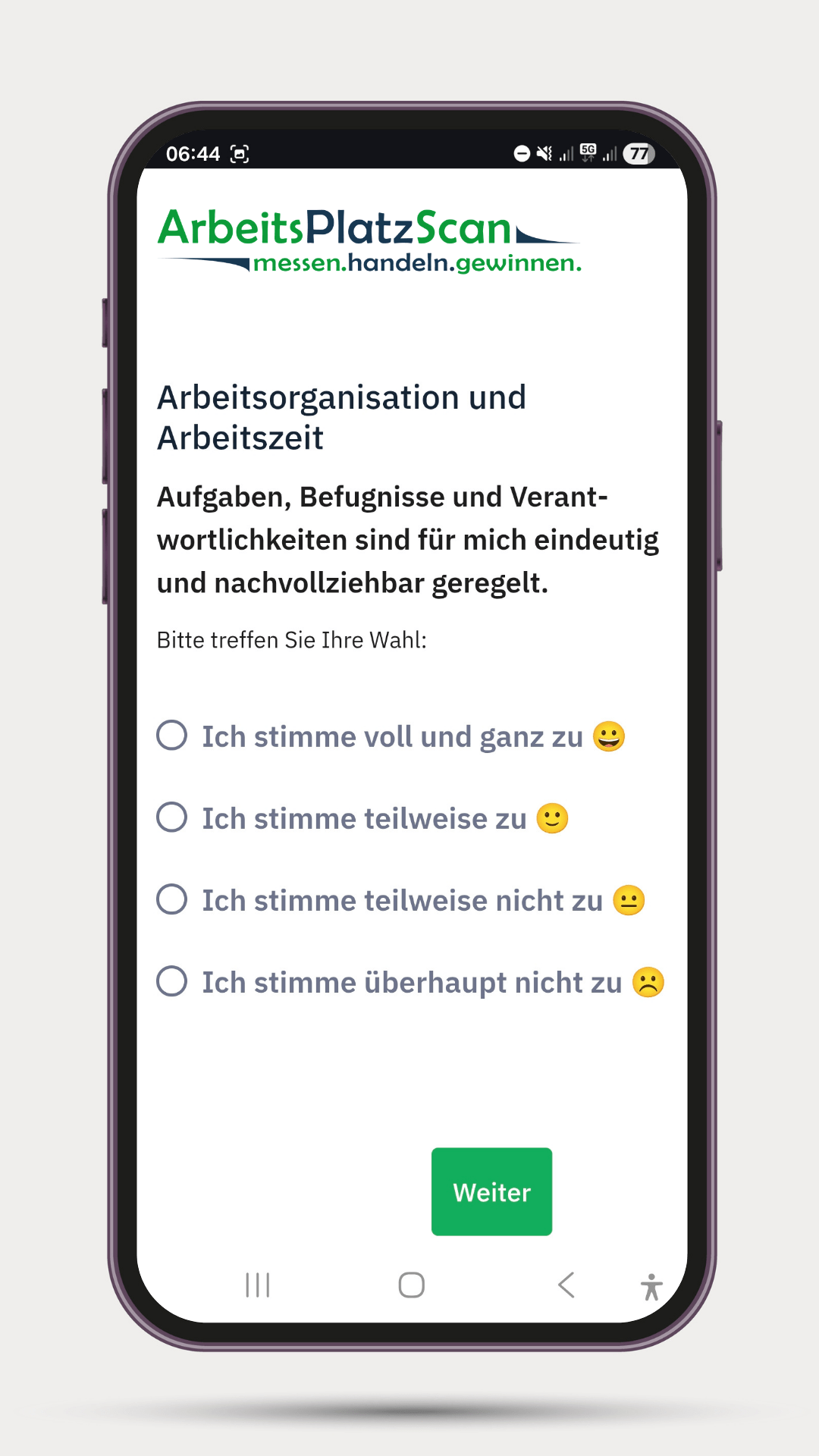 Smartphone zeigt Umfrage des ArbeitsPlatz-Scan zur Arbeitsorganisation und Arbeitszeit mit vier Antwortmöglichkeiten von Zustimmung bis Ablehnung und einem grünen Weiter-Button.